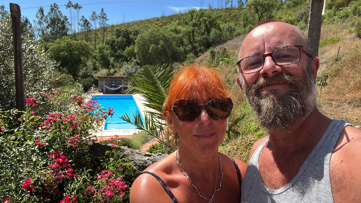 Two people standing in a garden beside a swimming pool in Central Portugal